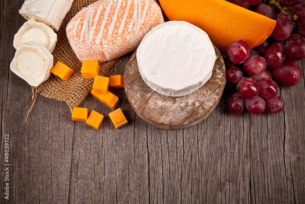 Delicious fresh french cheeses served on wooden table