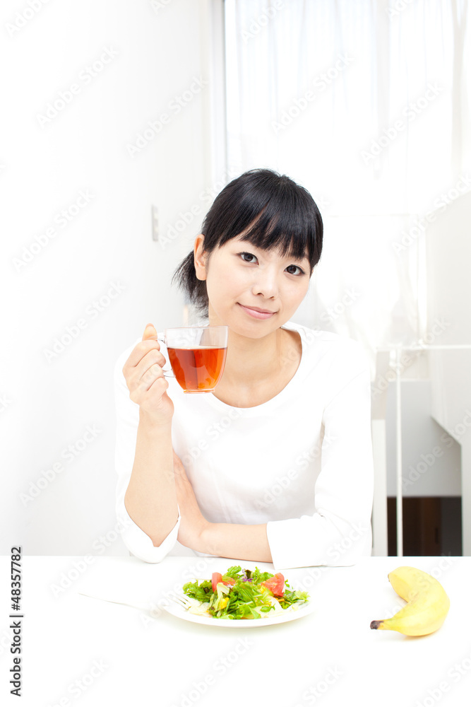 a young asian woman eating salad