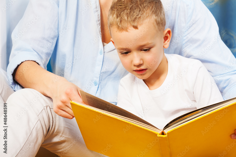 Reading a book with mothers help