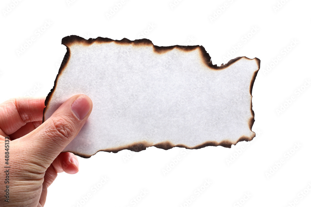 Hand holding piece of burned paper