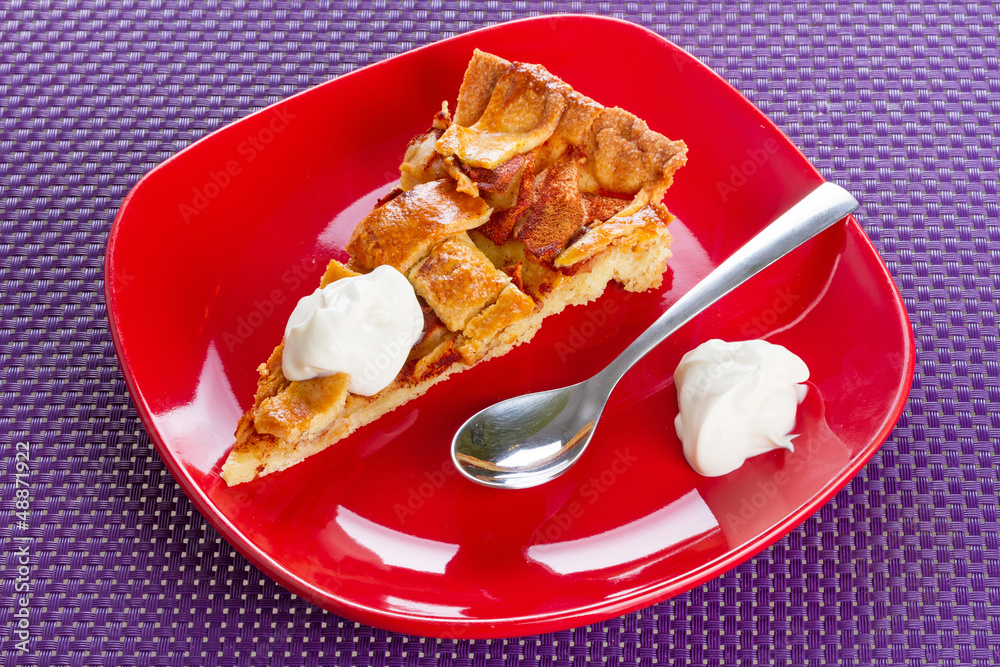 Piece of apple tart and cream on the plate