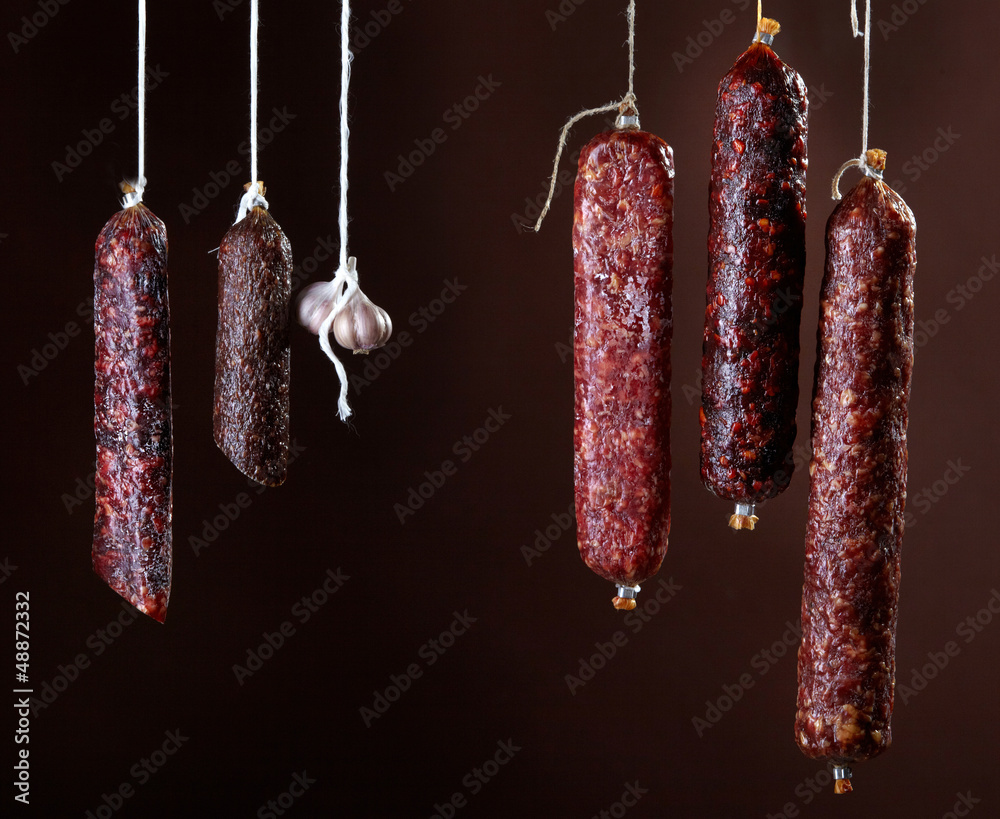 various hanging salami sausages