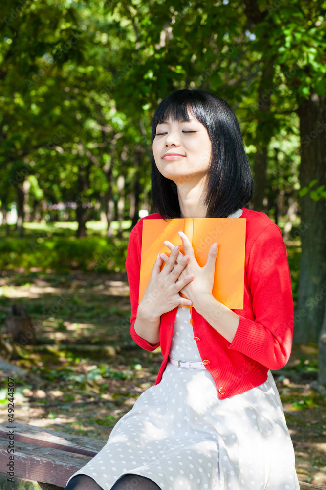 一个活跃的亚洲女人在公园里看书