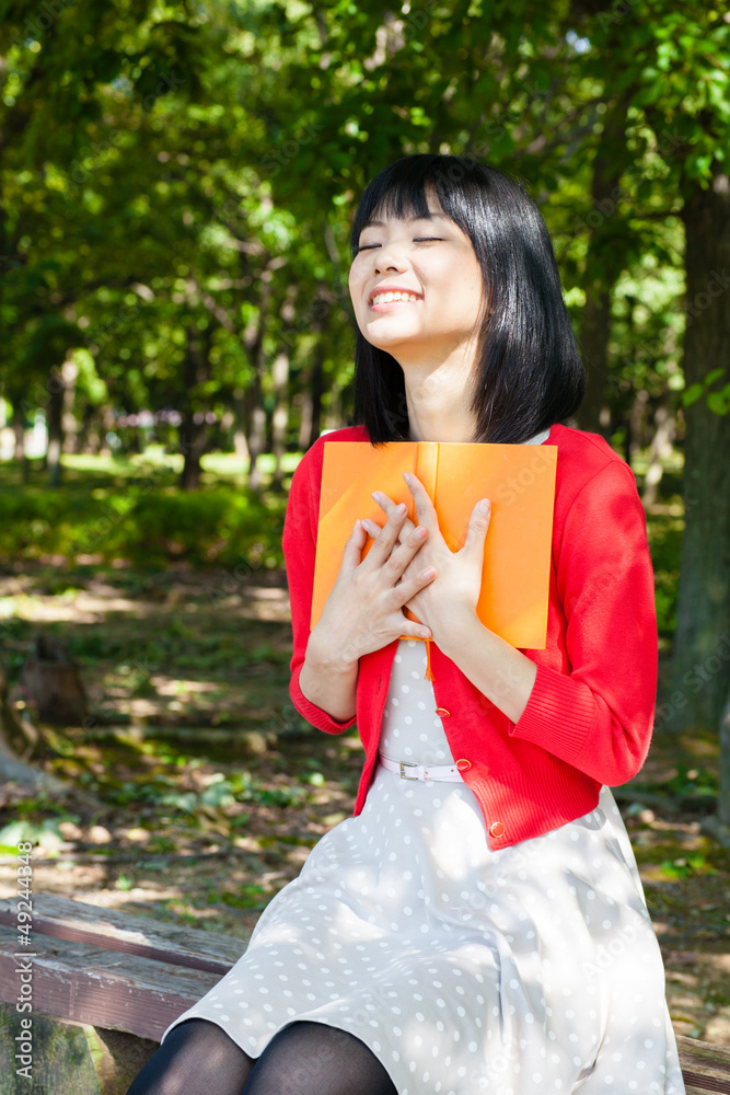 一个活跃的亚洲女人在公园里看书