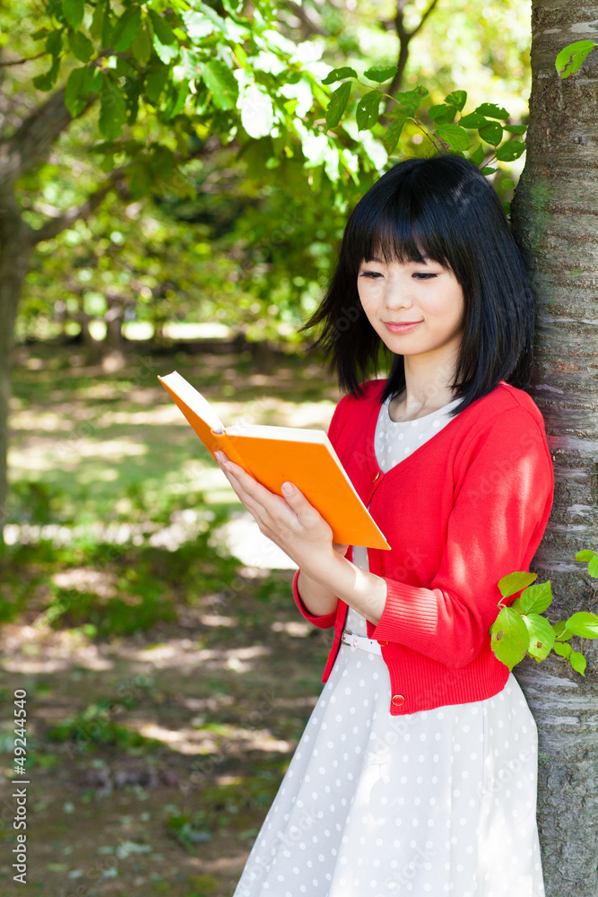 一个活跃的亚洲女人在公园里看书