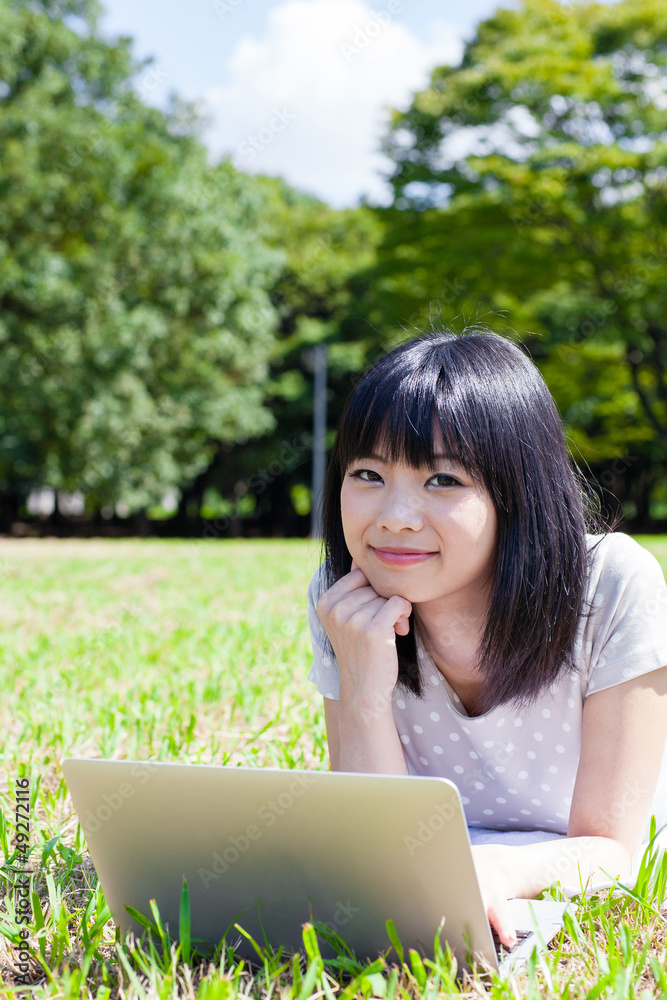 在公园里使用智能手机的亚洲美女