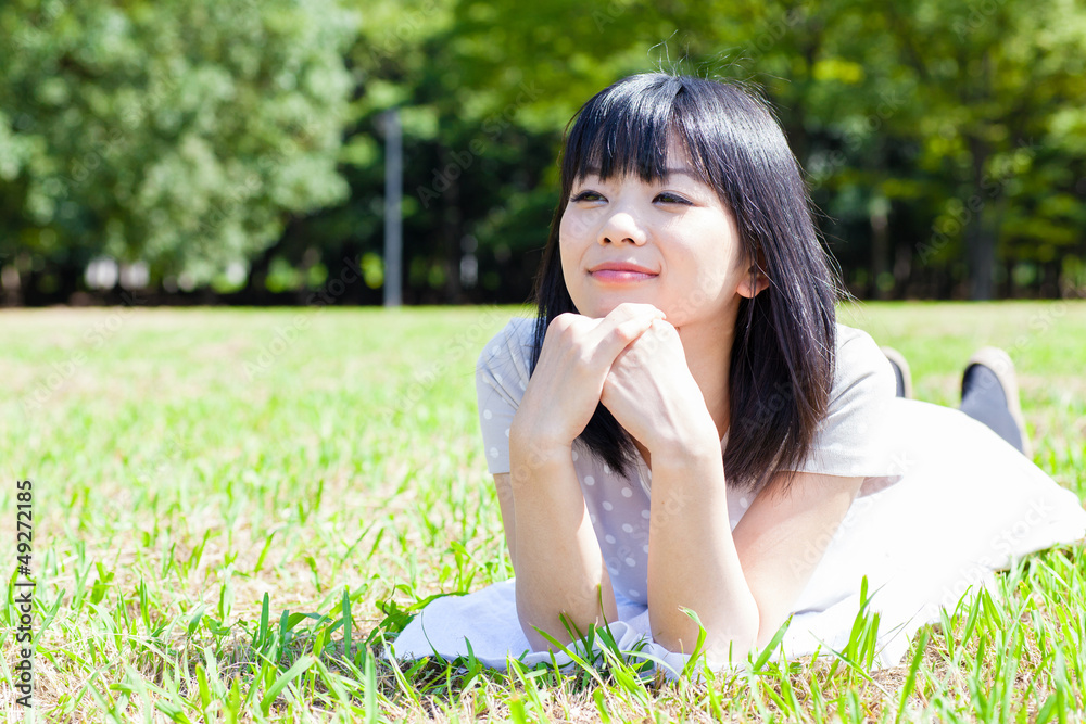 迷人的亚洲女人在公园放松