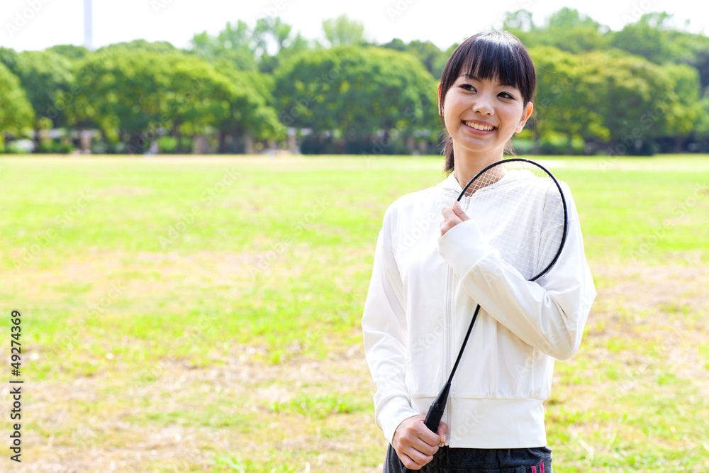 attractive asian woman with racket in the park