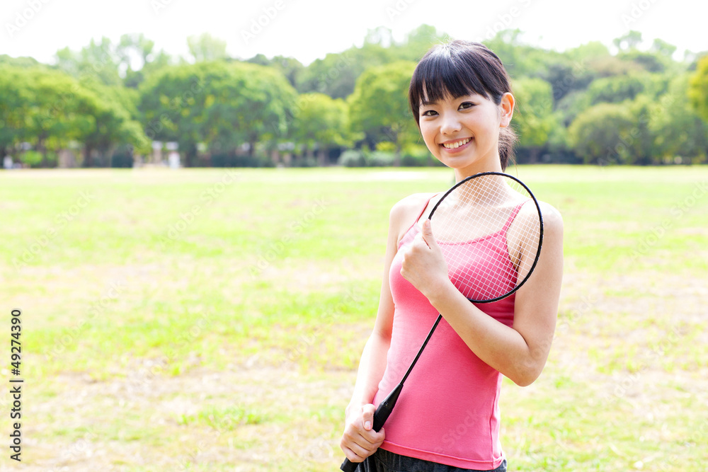 attractive asian woman with racket in the park