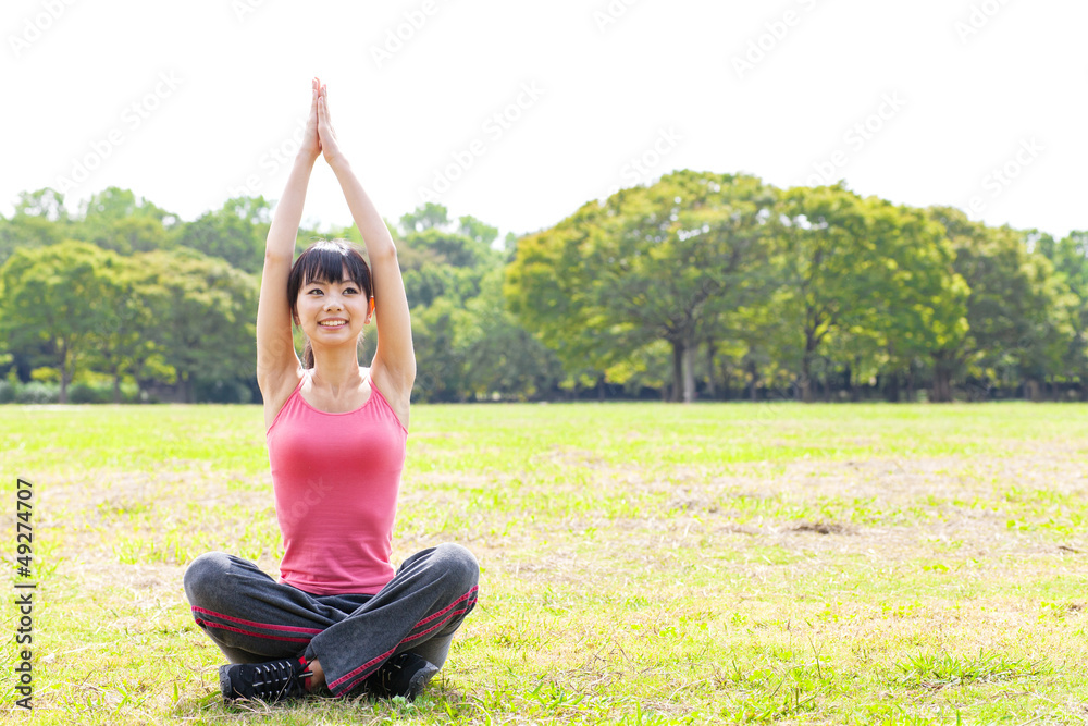 attractive asian woman stretching in the park