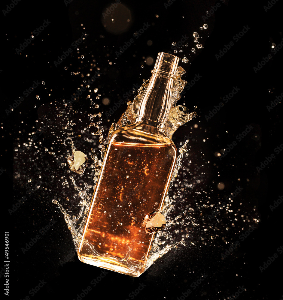 Concept of liquor splashing around bottle on black background