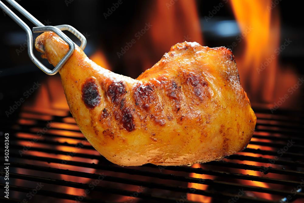 Grilled chicken thigh on the flaming grill