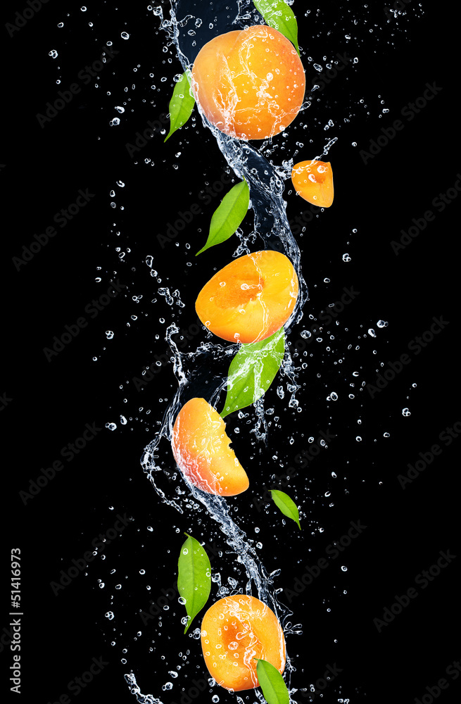 Apricots in water splash, isolated on black background