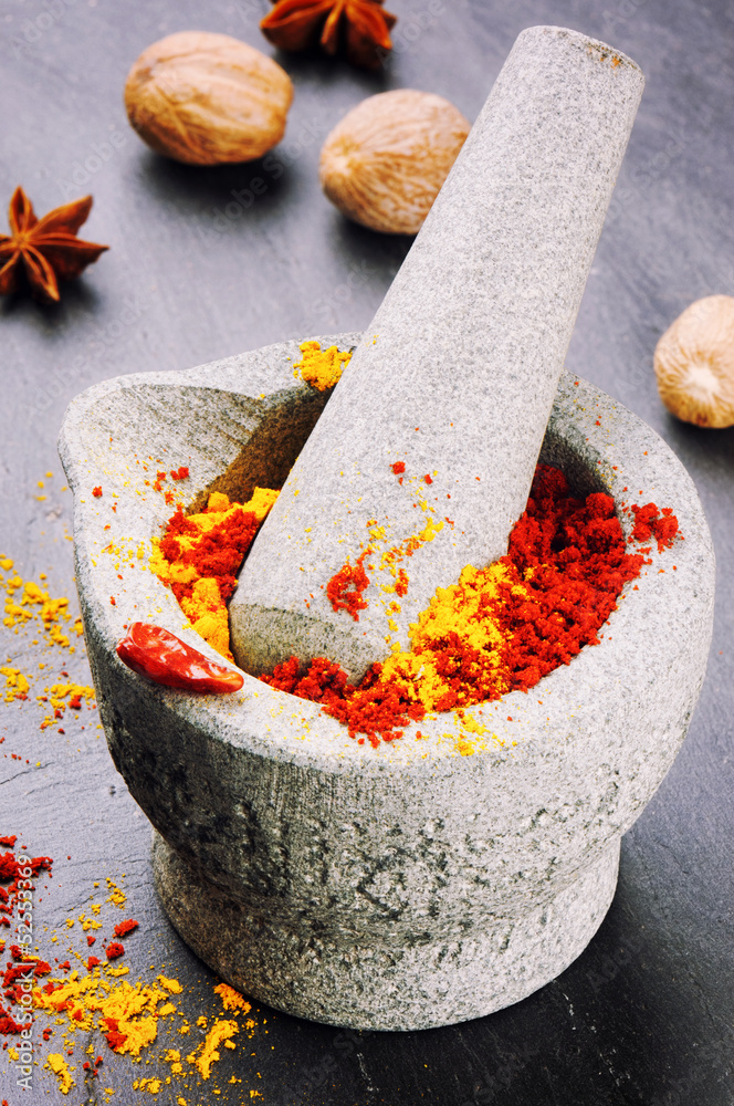 Mortar with chili pepper and curry powder