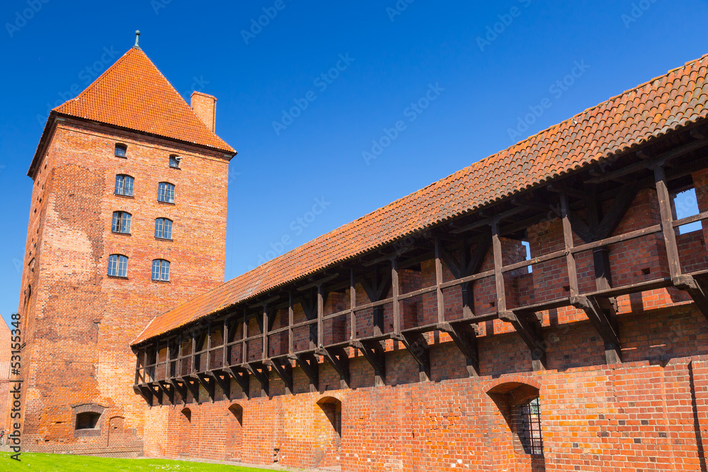 The wall and towers of Malbork castle in summer scenery, Poland