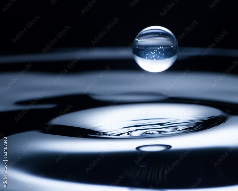 Drop of water flying from above, blue color