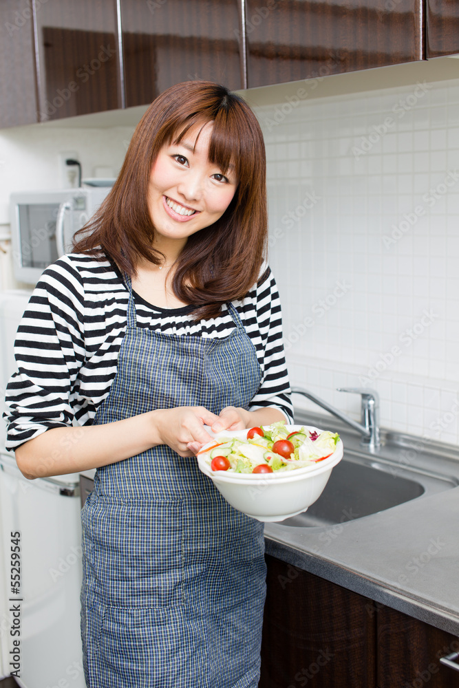 美丽的亚洲女人在厨房做饭