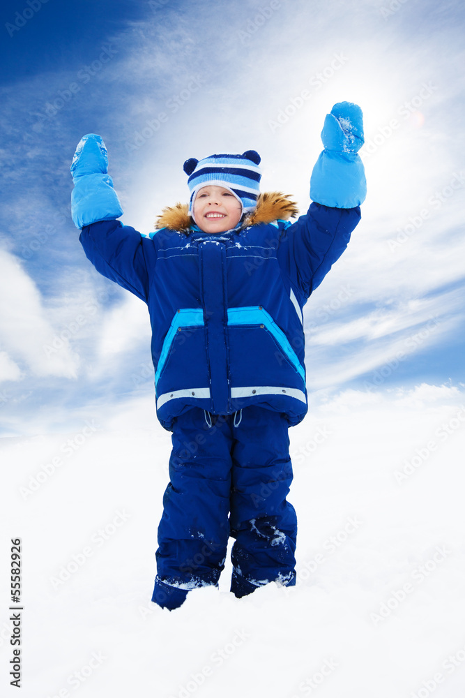 快乐的男孩双手举着雪橇站着