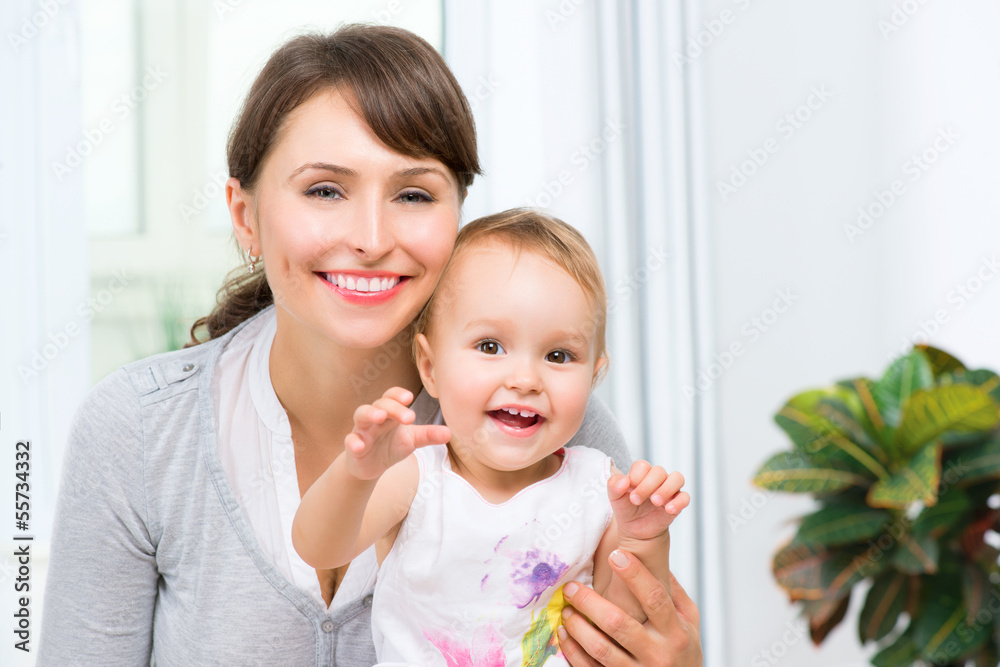 Happy Smiling Mother and Baby kissing and hugging at Home