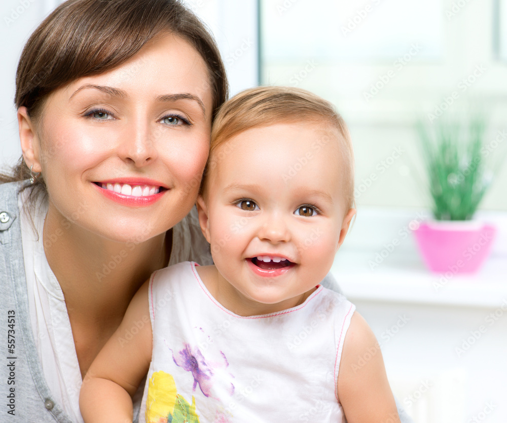 Happy Smiling Mother and Baby kissing and hugging at Home