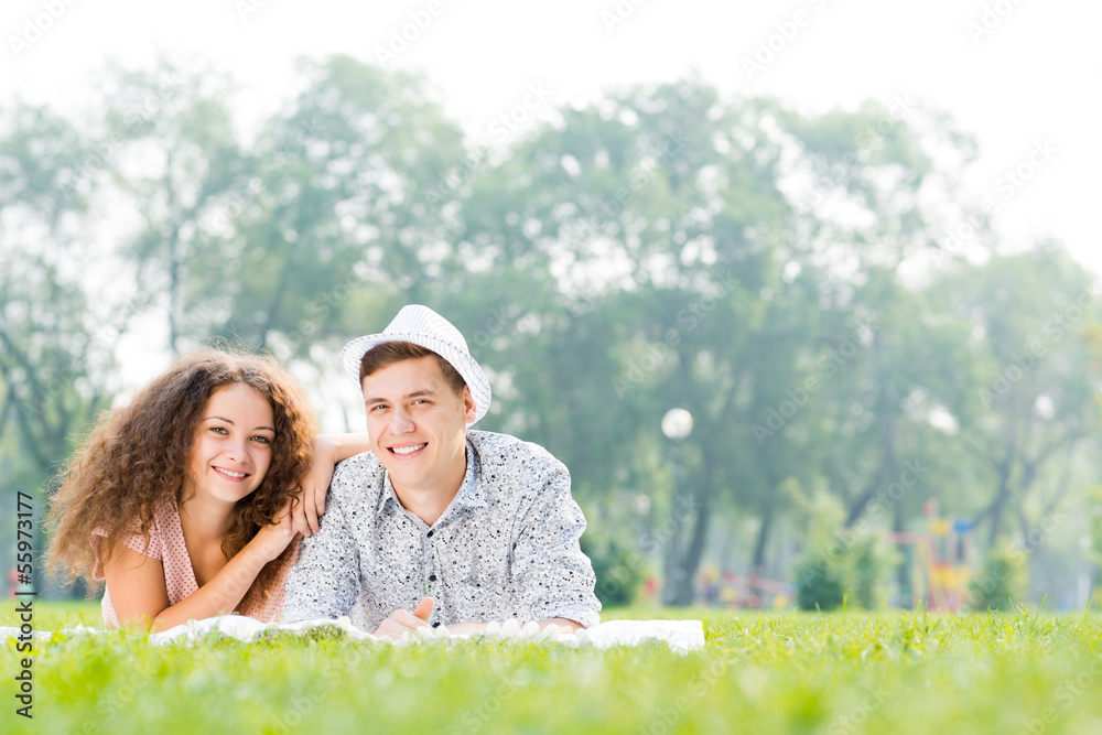 couple lying on the grass in the summer park