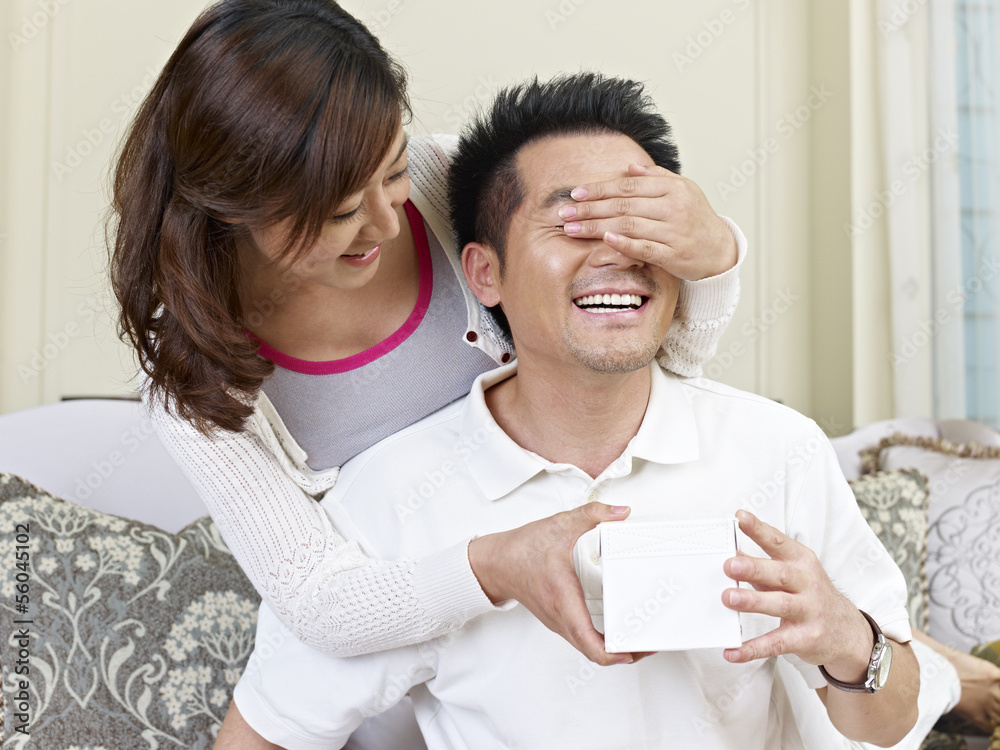 wife giving surprise gift to husband