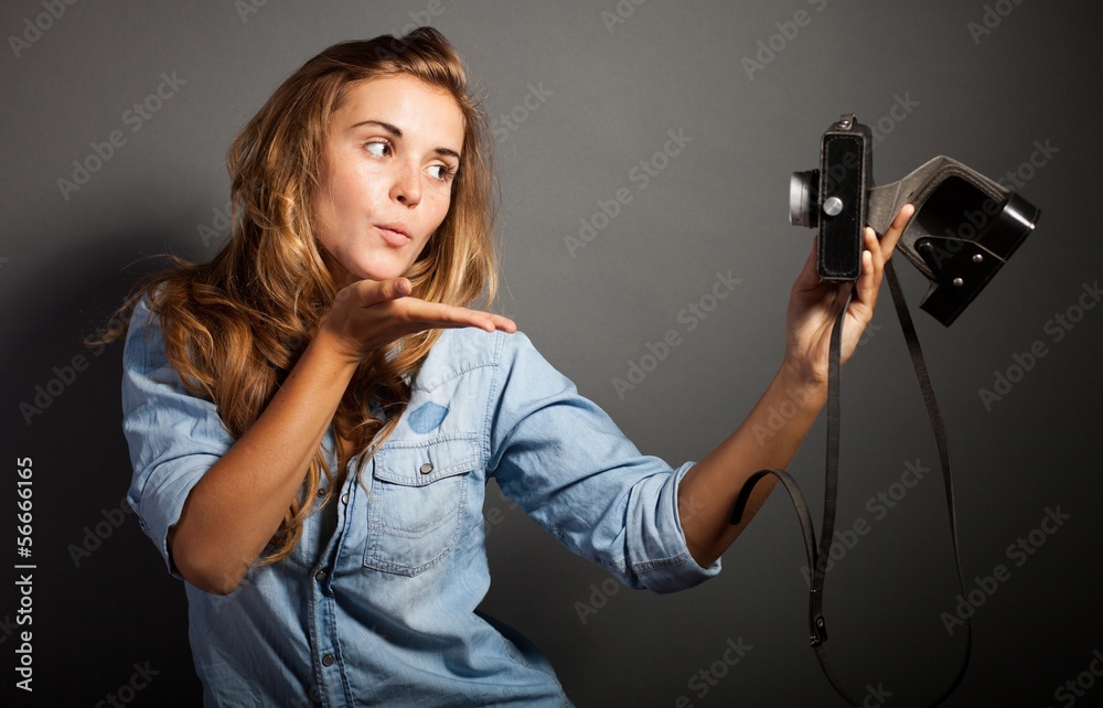 Photographer woman taking pictures herself with old camera