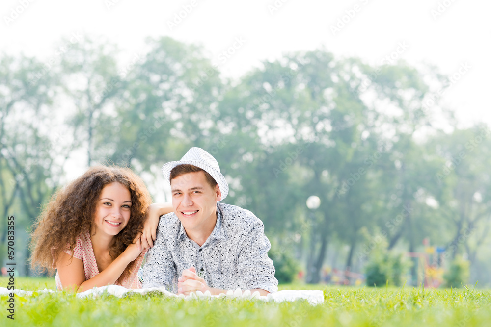 couple lying on the grass in the summer park