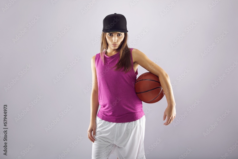 Beautiful female basketball player on grey background