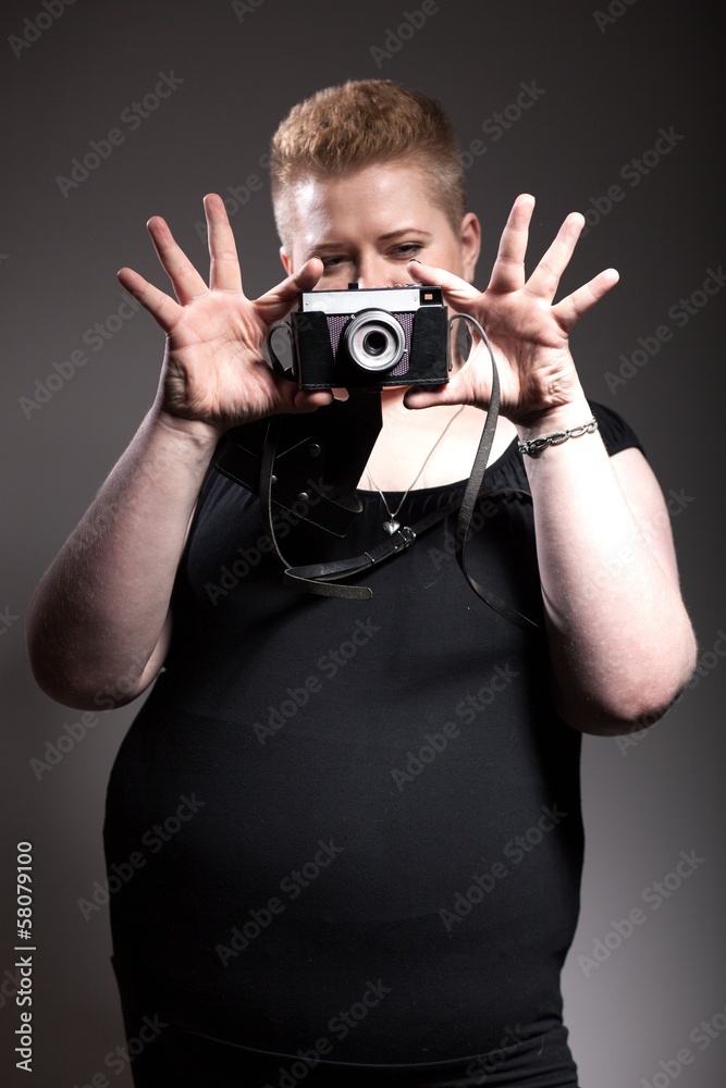 Chubby woman taking pictures of old camera