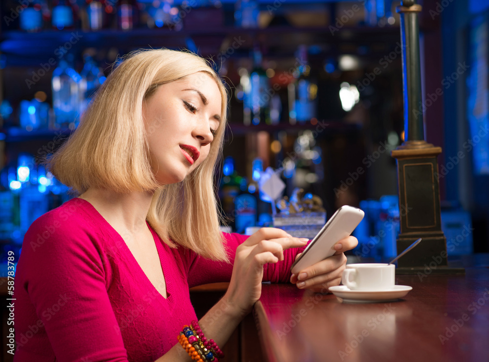 woman with a cup of coffee and cell phone