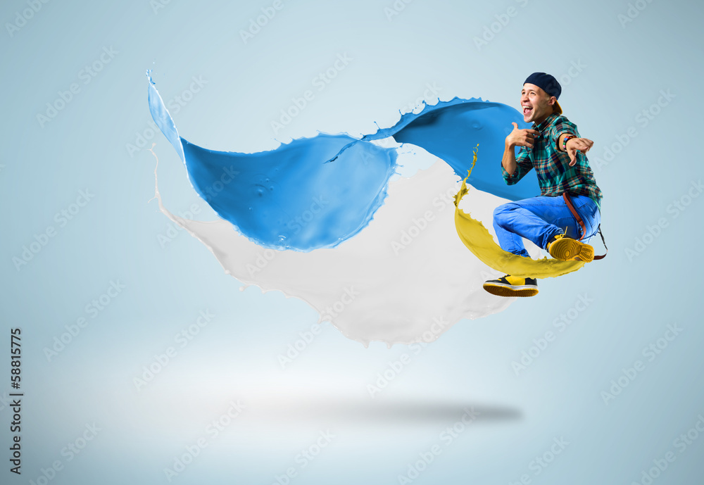 young male dancer jumping with splash of paint