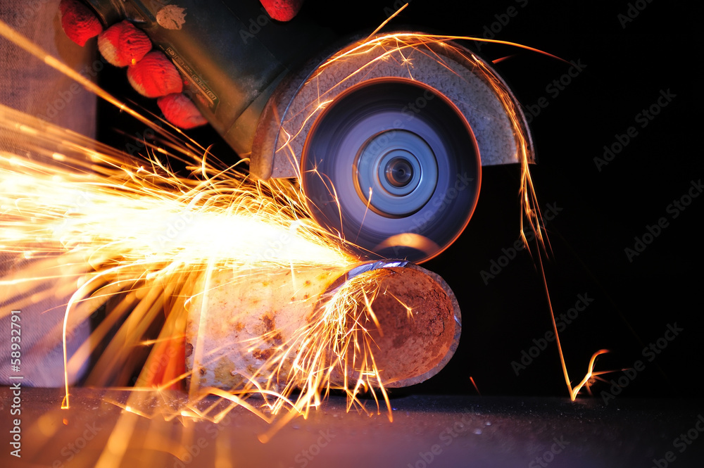 Worker cutting metal with grinder