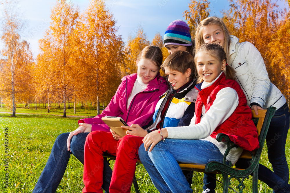 Teens with gadget in park