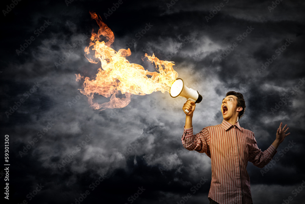 Portrait of a young man shouting using megaphone