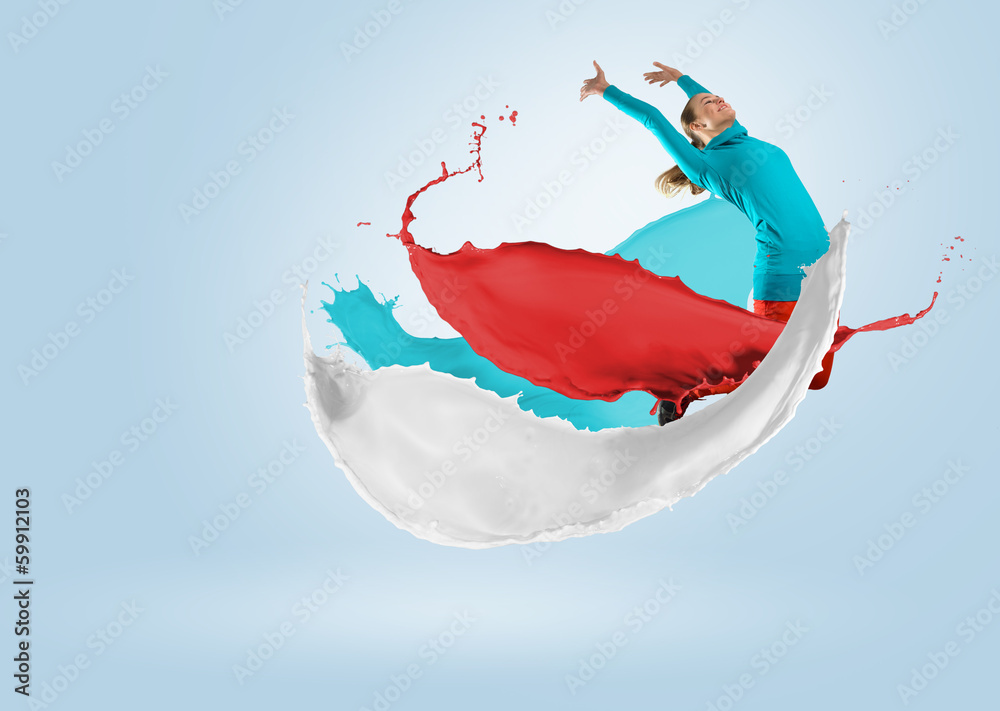 young female dancer jumping with splash of paint