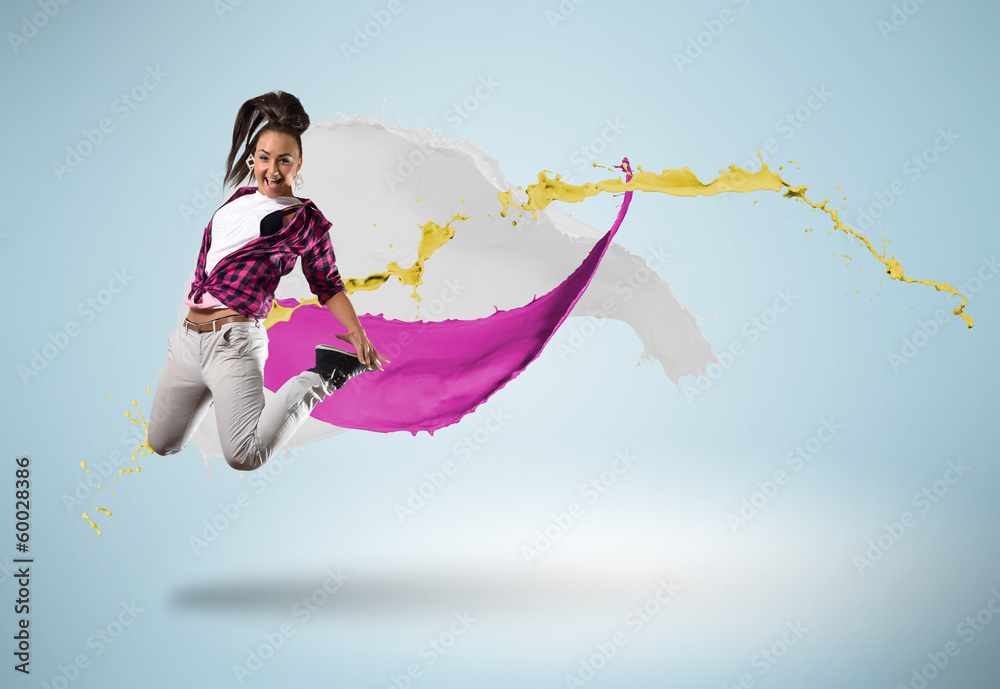 young female dancer jumping with splash of paint