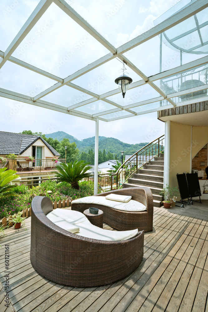 Home exterior patio with wooden decking and rattan sofa