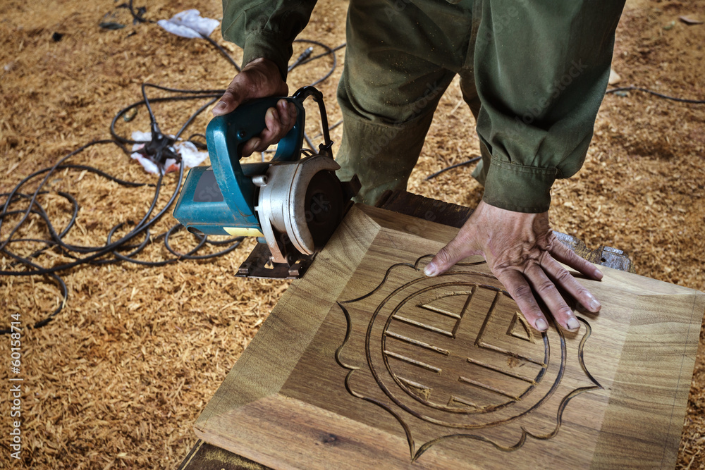 man cutting wood by machine