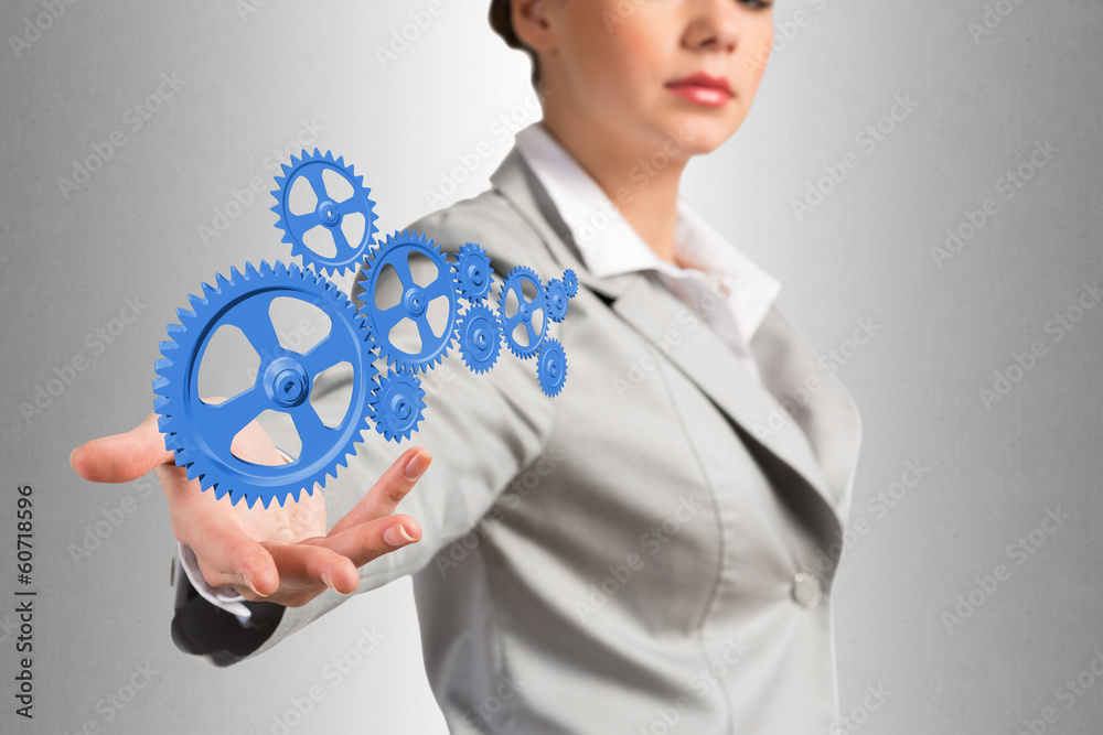 business woman holds up a mechanism of gears