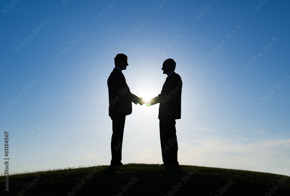 Silhouette of Two Businessmen Shaking Hands