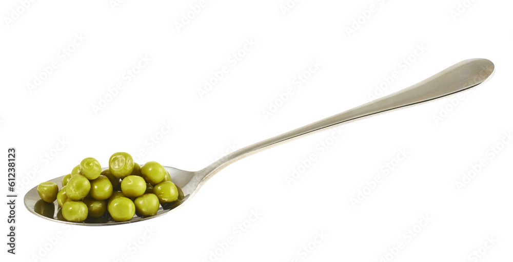 Steel spoon full of green peas isolated