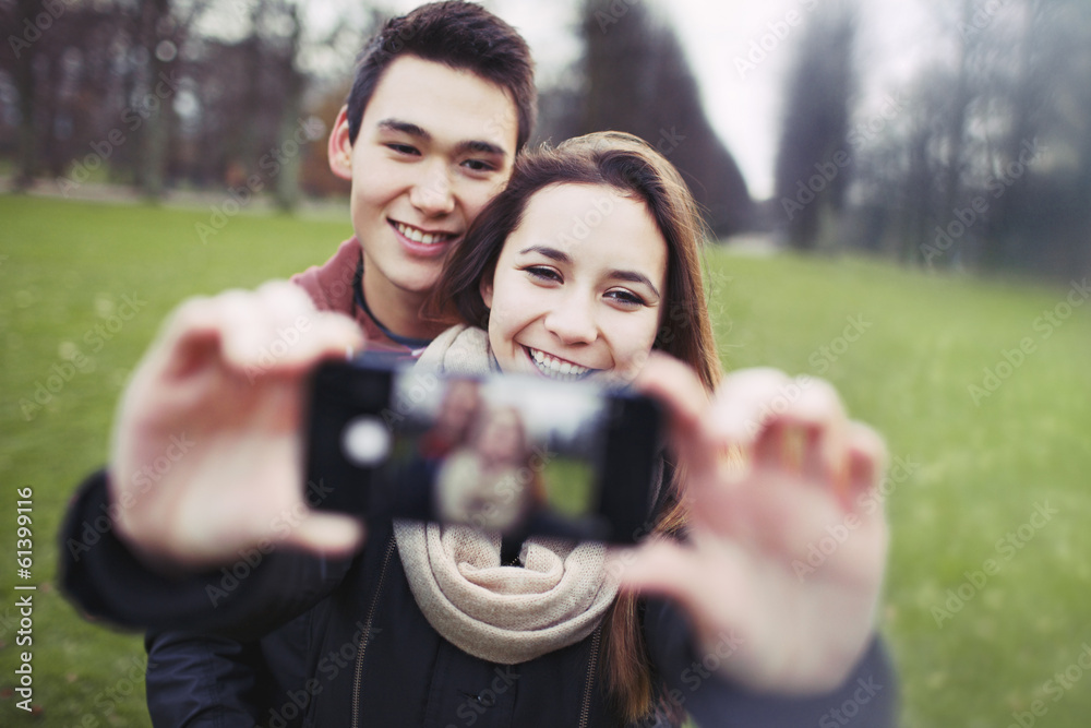 Young couple looking happy taking self portrait