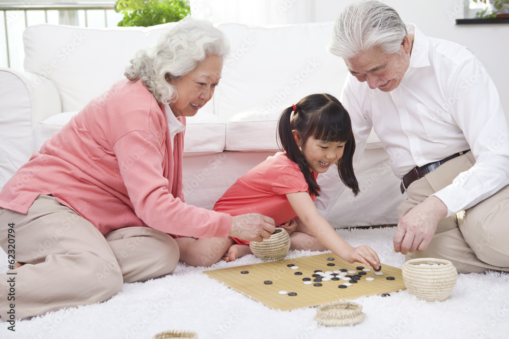 。一对老夫妇带着孙女玩围棋。