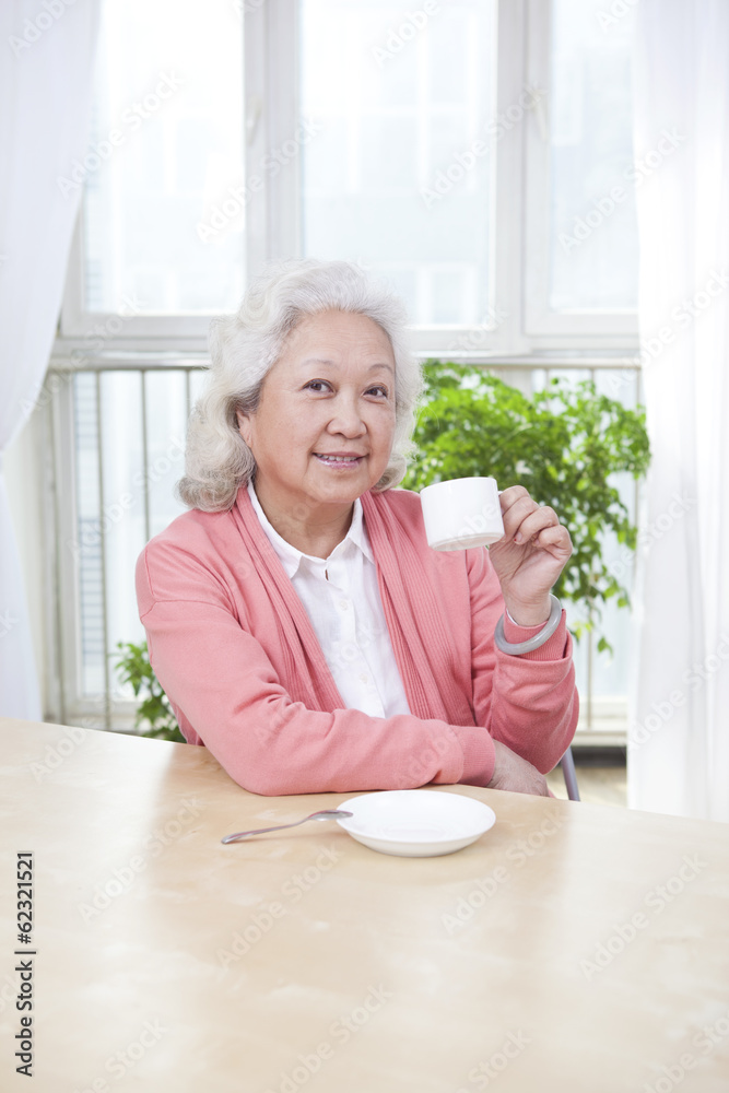 拿着茶杯的老年妇女。