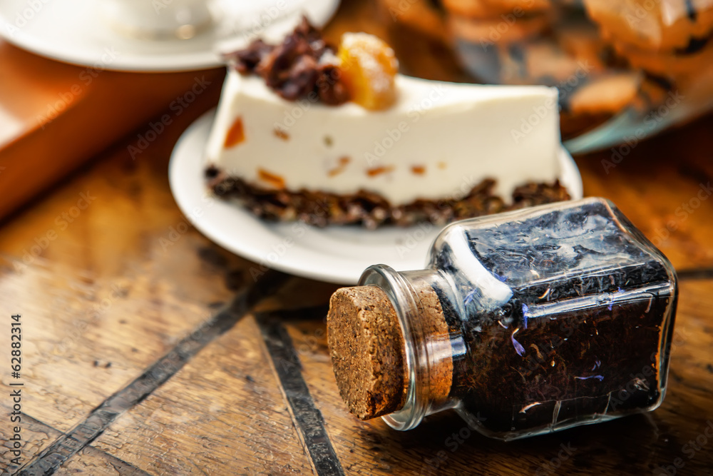 Leaf tea in a jar and a piece of cheesecake