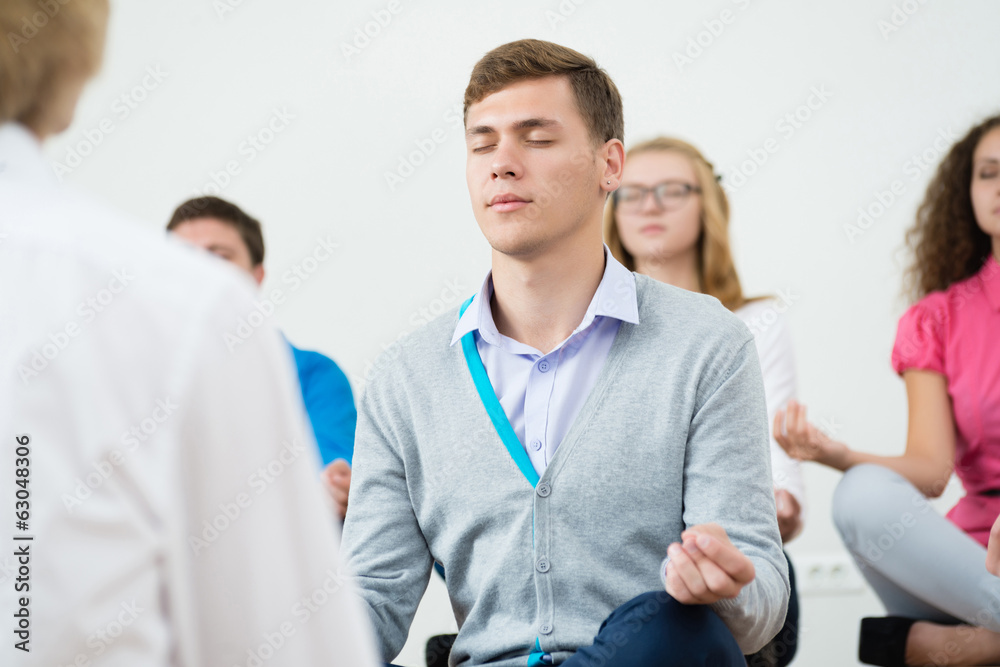 group of young people meditating