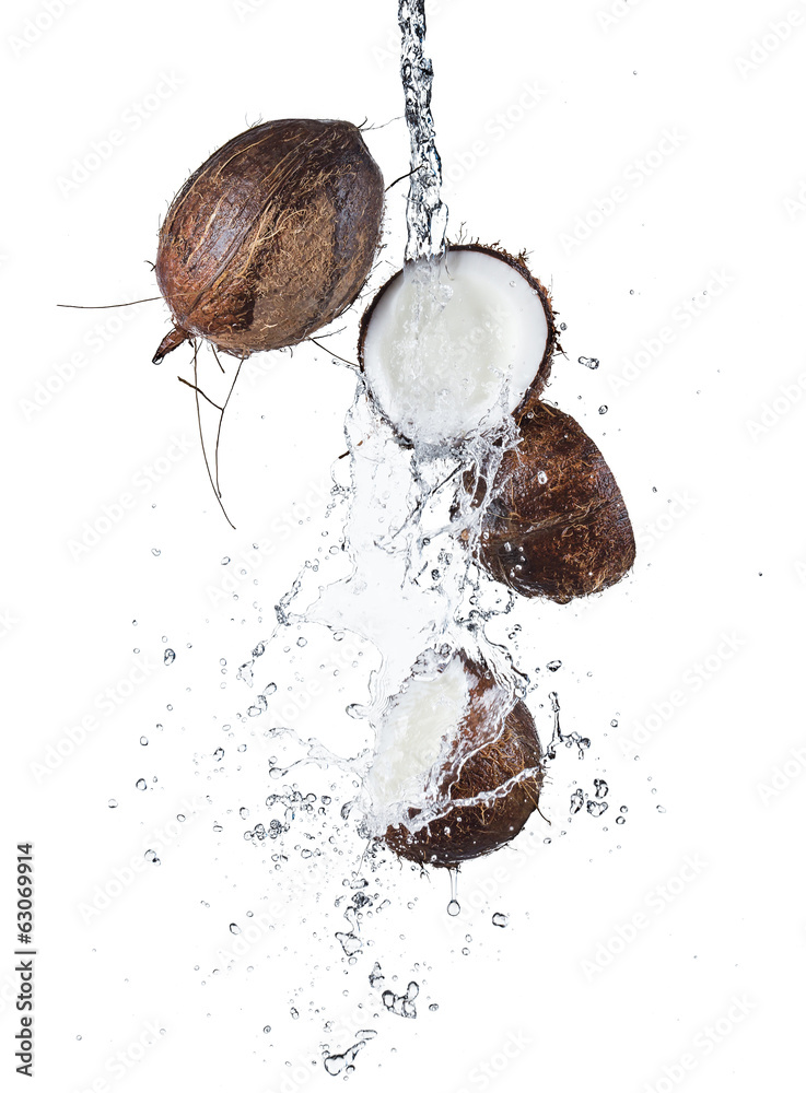 Cracked coconuts in water splash on white