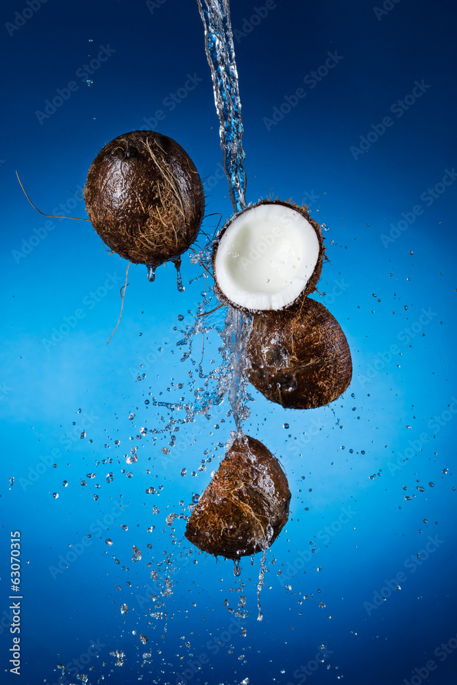 Cracked coconuts in water splash