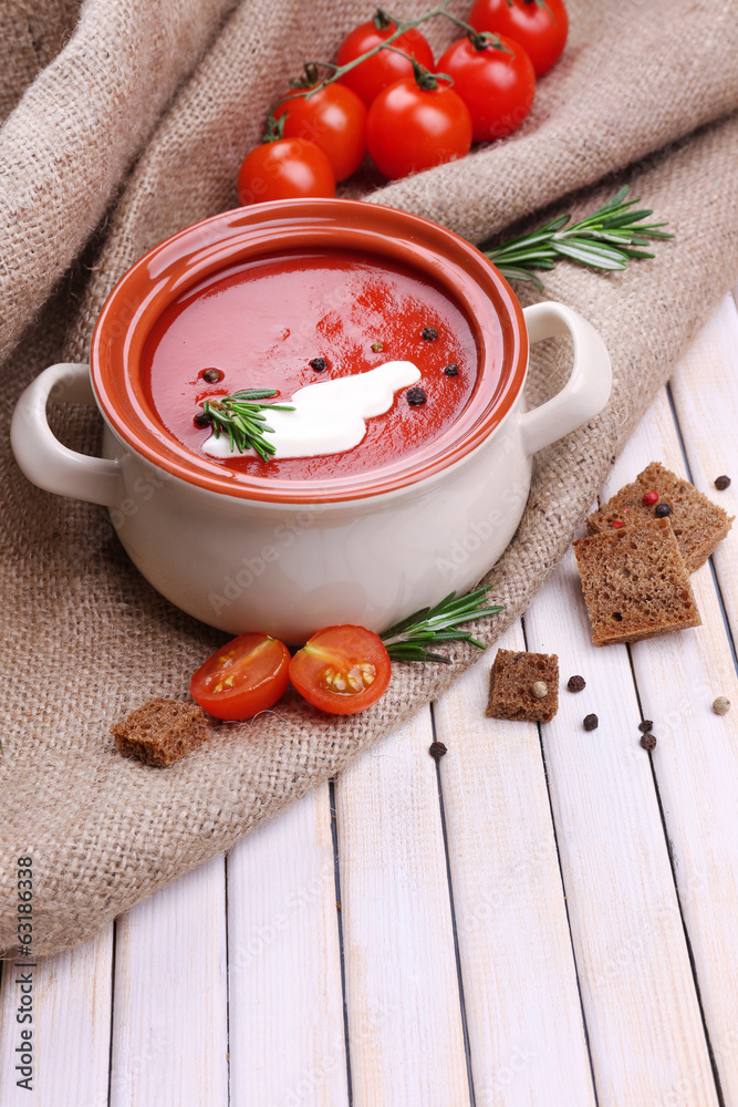 Tasty tomato soup on wooden table